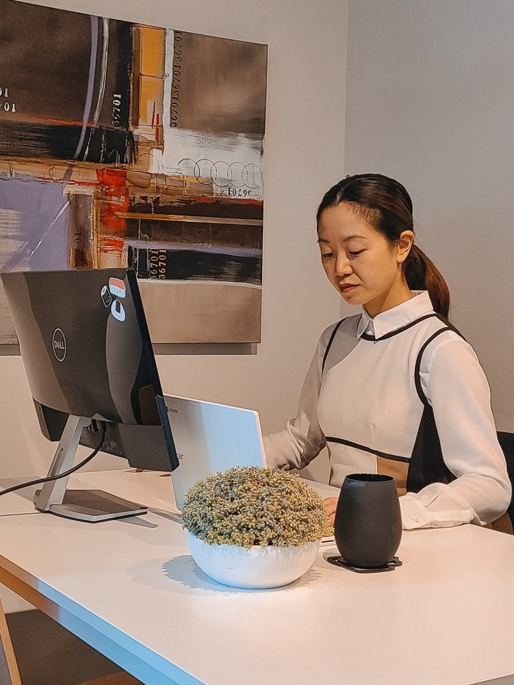 Young woman in color-block work dress and collared shirt sitting in front of computer screen and tablet working from home in Envie Rideau development. #wfh #workwear #workfromhome #wfh #hybrid